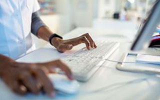 A doctor working at a computer terminal
