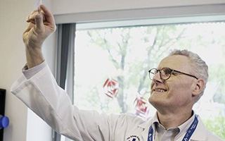 Le Dr Michael Schlossmacher observe une éprouvette dans son laboratoire